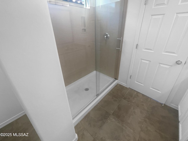 full bathroom featuring a stall shower, baseboards, and tile patterned floors