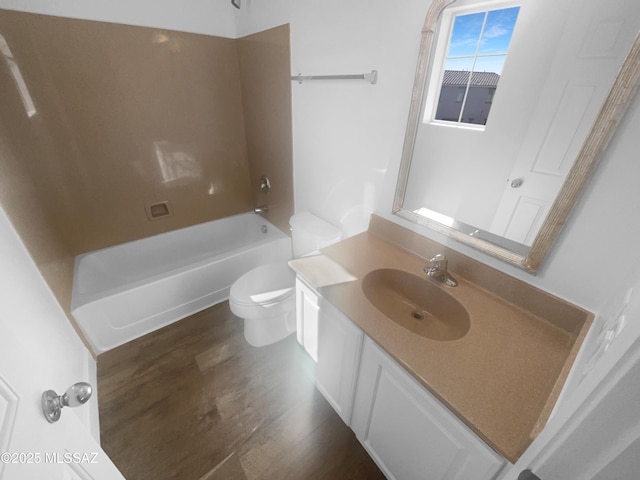 bathroom featuring vanity, bathing tub / shower combination, wood finished floors, and toilet