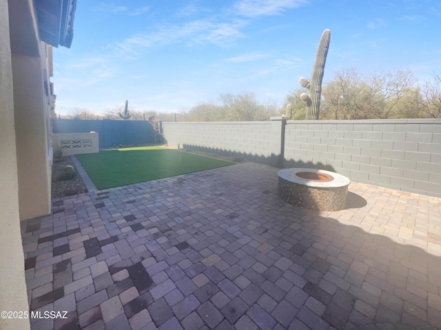 view of patio with a fenced backyard and a fire pit