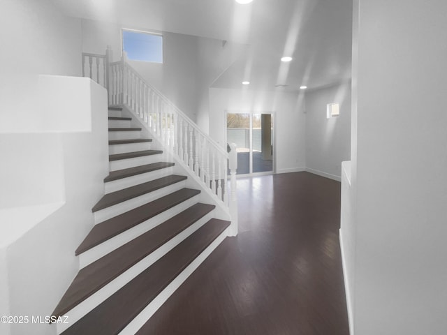 stairs featuring recessed lighting, plenty of natural light, baseboards, and wood finished floors