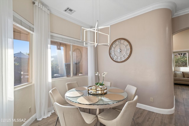 dining area with baseboards, wood finished floors, visible vents, and ornamental molding