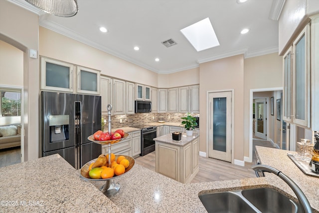 kitchen with electric stove, a sink, a skylight, stainless steel fridge with ice dispenser, and visible vents