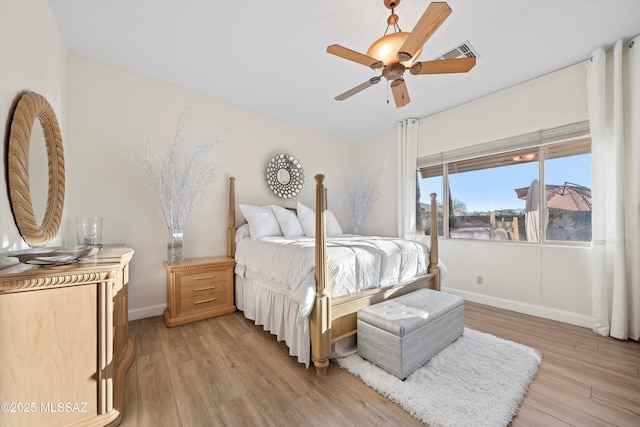 bedroom featuring a ceiling fan, visible vents, light wood-style floors, and baseboards