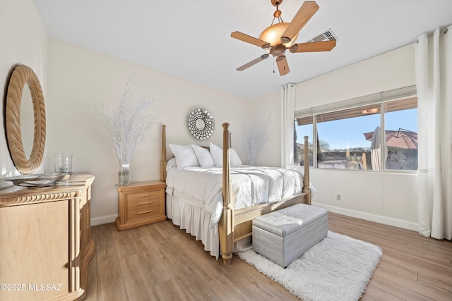 bedroom with baseboards, a ceiling fan, visible vents, and light wood finished floors