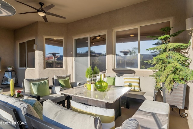 view of patio featuring outdoor dining space, an outdoor hangout area, and a ceiling fan