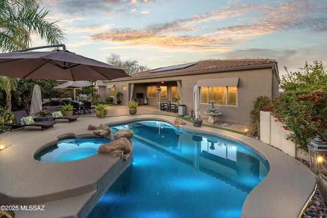 view of pool with a patio, outdoor dining space, and a pool with connected hot tub