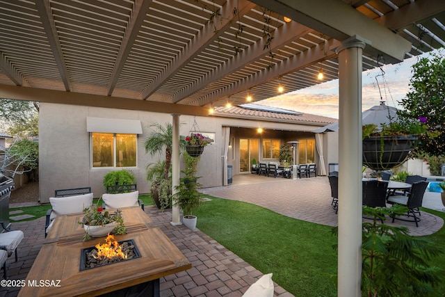 view of patio with outdoor dining space, a pergola, and an outdoor fire pit