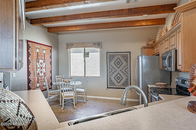 kitchen with visible vents, baseboards, a sink, stainless steel appliances, and beam ceiling