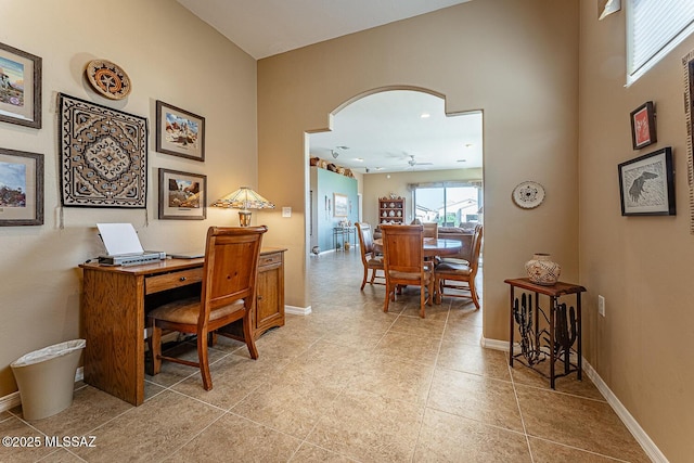 office with arched walkways, light tile patterned flooring, and baseboards