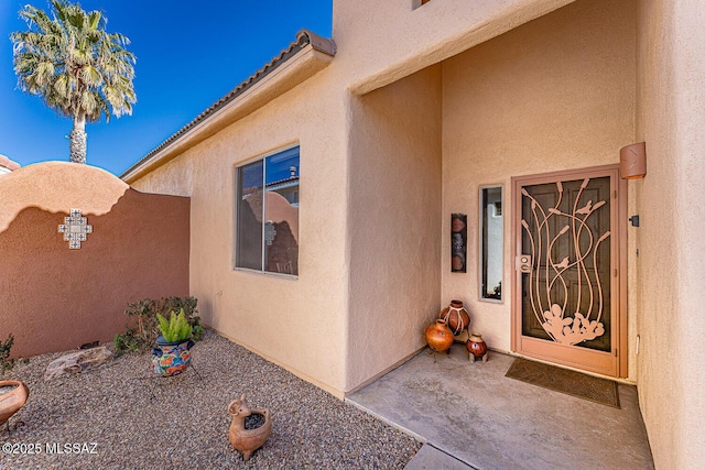 doorway to property featuring stucco siding