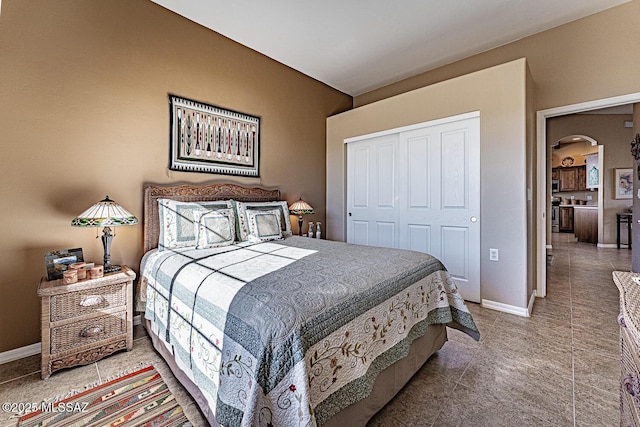 bedroom featuring baseboards, a closet, and tile patterned floors