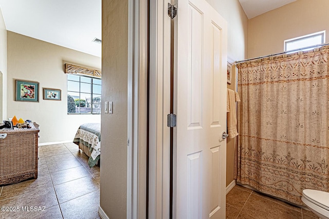 bathroom featuring ensuite bathroom, tile patterned flooring, toilet, a shower with shower curtain, and baseboards