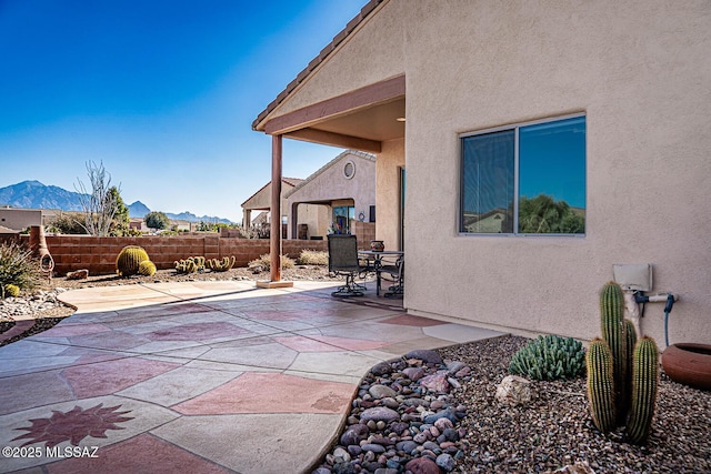 view of patio / terrace featuring fence and a mountain view