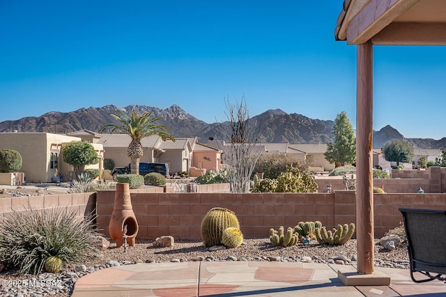 view of patio / terrace featuring a residential view, a mountain view, and fence