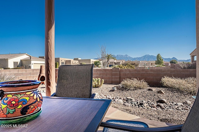 exterior space with a fenced backyard, a residential view, and a mountain view