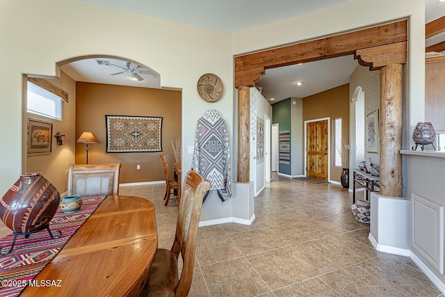 dining room with a ceiling fan, arched walkways, and baseboards