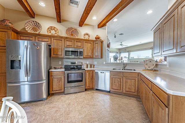 kitchen with stainless steel appliances, a sink, visible vents, light countertops, and brown cabinetry