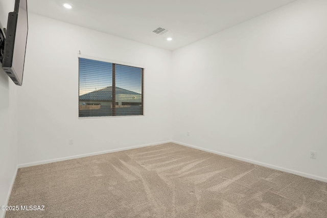 empty room with carpet floors, recessed lighting, visible vents, and baseboards