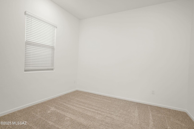 carpeted spare room featuring baseboards