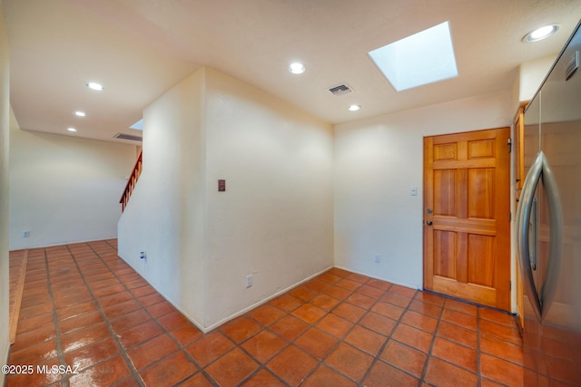 tiled empty room featuring a skylight, visible vents, and recessed lighting