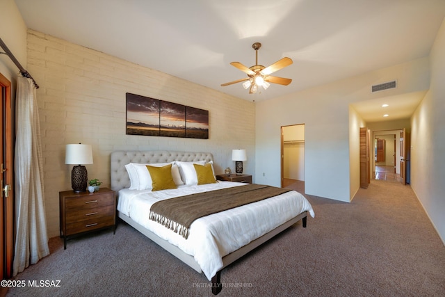 carpeted bedroom with a walk in closet, a closet, visible vents, and ceiling fan