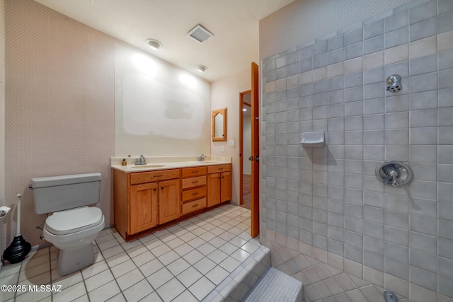 bathroom with visible vents, tiled shower, a sink, and tile patterned floors