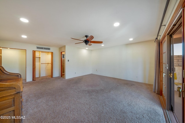 carpeted spare room featuring ceiling fan, visible vents, and recessed lighting