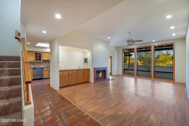 unfurnished living room with wood finished floors, stairway, a tile fireplace, and recessed lighting