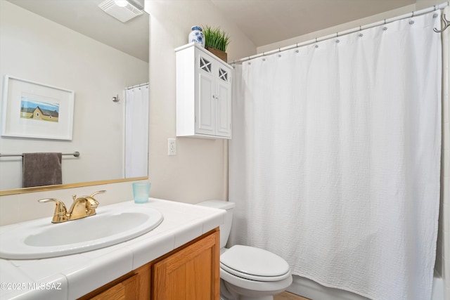 bathroom featuring toilet, vanity, and walk in shower