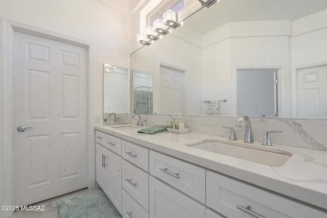 full bathroom featuring marble finish floor, double vanity, and a sink