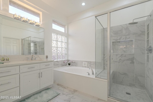 bathroom with a stall shower, marble finish floor, a garden tub, vanity, and recessed lighting