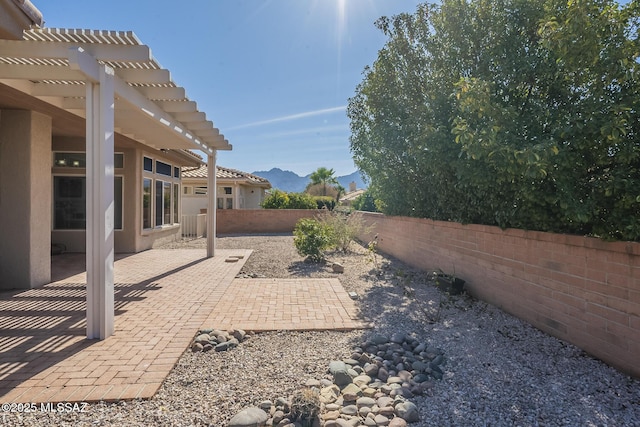 view of yard with a patio area, a mountain view, a fenced backyard, and a pergola