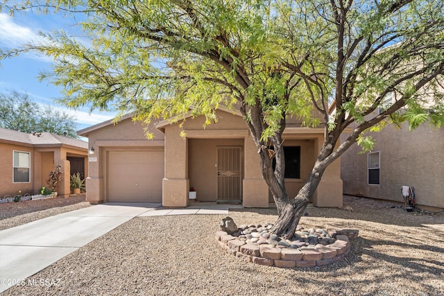 view of front facade featuring driveway, an attached garage, and stucco siding