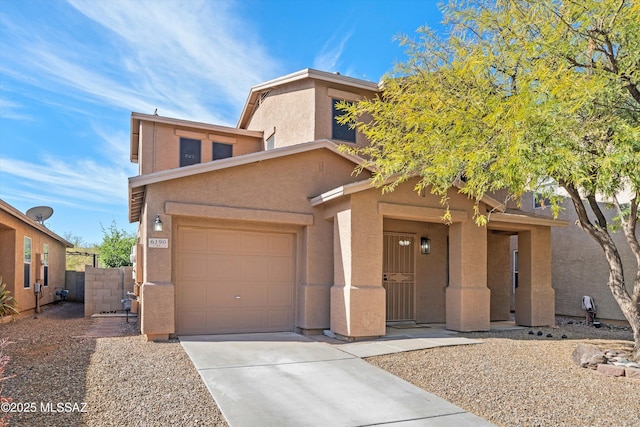 view of front of home with driveway, an attached garage, fence, and stucco siding