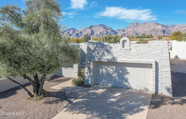 view of front facade with a garage, fence, and a mountain view