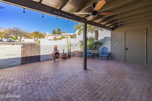 view of patio with ceiling fan, fence, and a gate