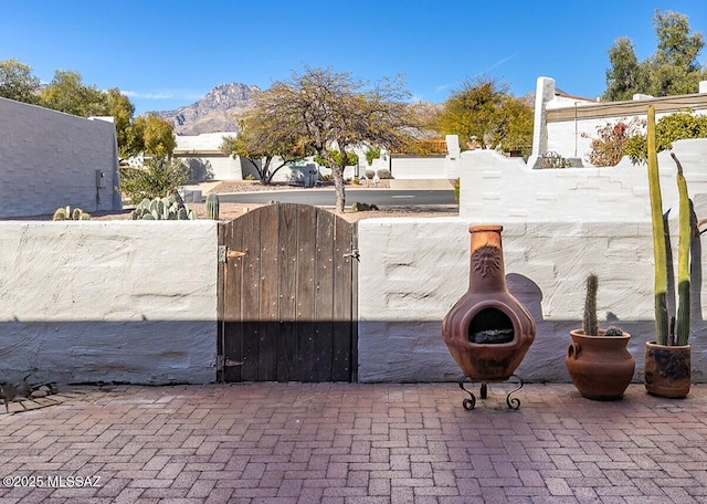 exterior space featuring a gate, a mountain view, and fence