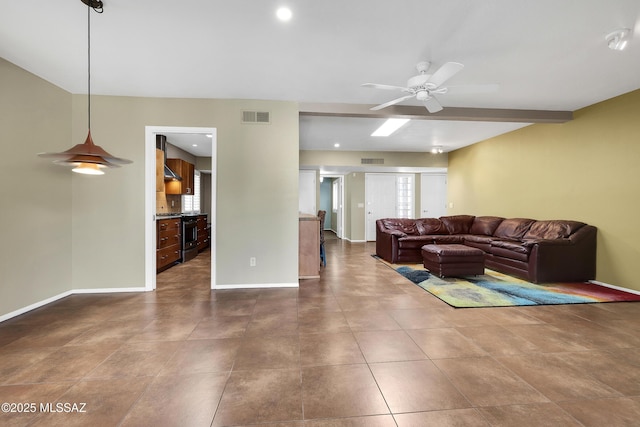 tiled living area with visible vents, ceiling fan, and baseboards