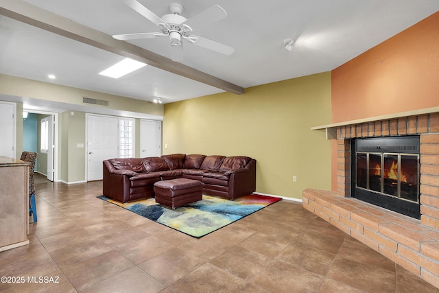 living room featuring a brick fireplace, visible vents, beamed ceiling, and baseboards