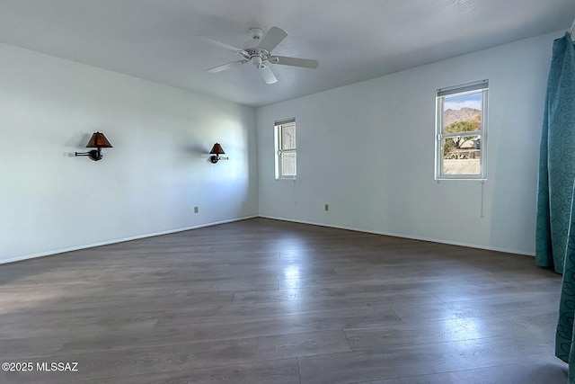 7471 E Serenity Ln, Tucson, AZ 85750 - unfurnished room featuring plenty of natural light, wood finished floors, a ceiling fan, and baseboards