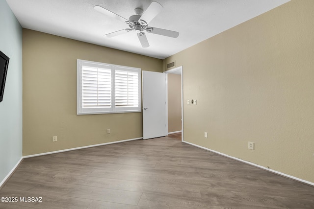 spare room with ceiling fan, baseboards, visible vents, and light wood-style floors