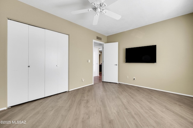 unfurnished bedroom with light wood-style floors, baseboards, visible vents, and a closet