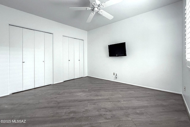 7471 E Serenity Ln, Tucson, AZ 85750 - unfurnished bedroom featuring multiple closets, dark wood-style floors, baseboards, and ceiling fan