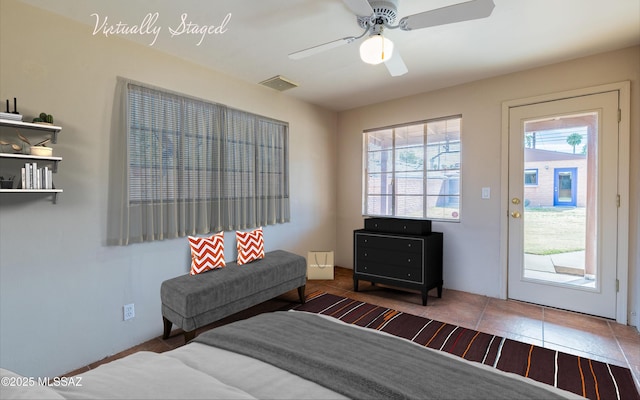 interior space with a ceiling fan, visible vents, and tile patterned floors