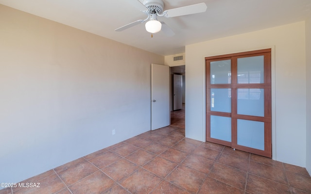 unfurnished room with visible vents and a ceiling fan