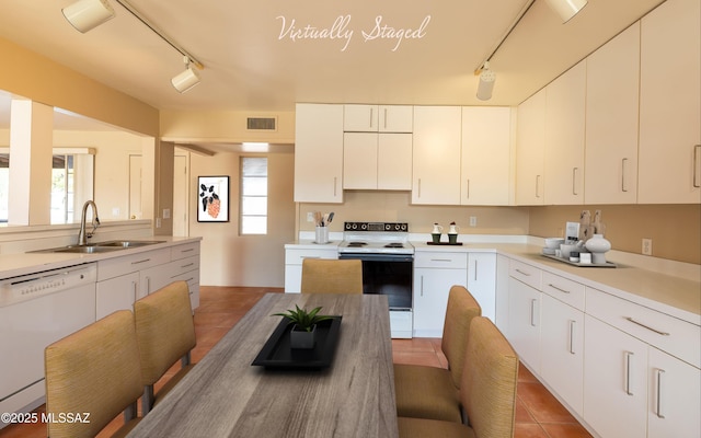 kitchen featuring white appliances, light tile patterned floors, visible vents, light countertops, and a sink