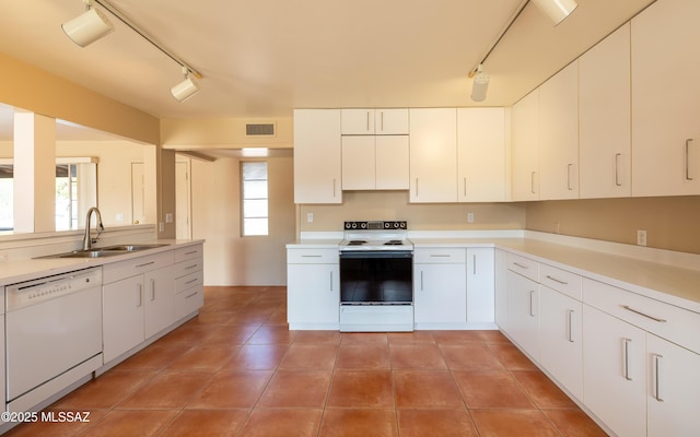 kitchen featuring light countertops, white appliances, visible vents, and a sink