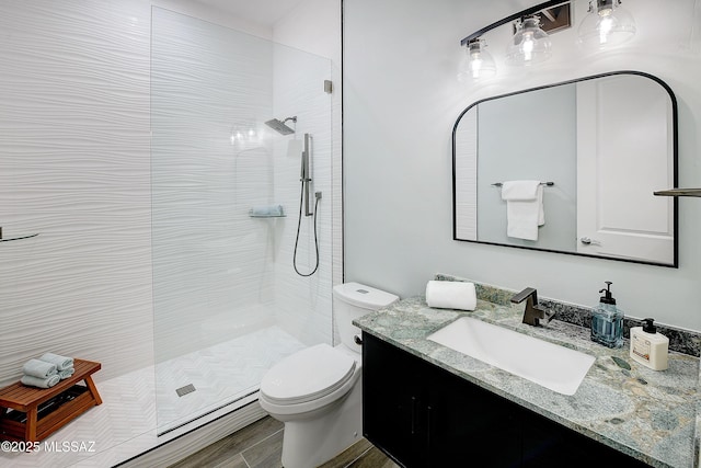 full bathroom featuring a walk in shower, wood finished floors, vanity, and toilet