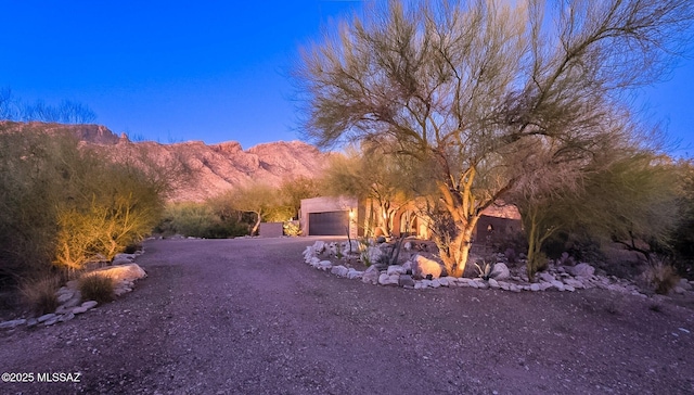 view of yard featuring driveway, a garage, and a mountain view