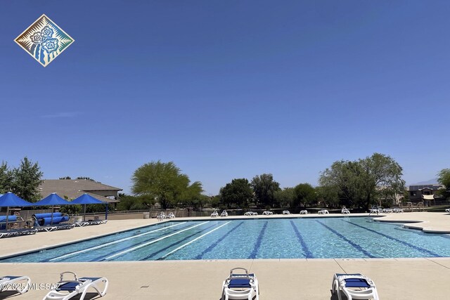 community pool with fence and a patio area